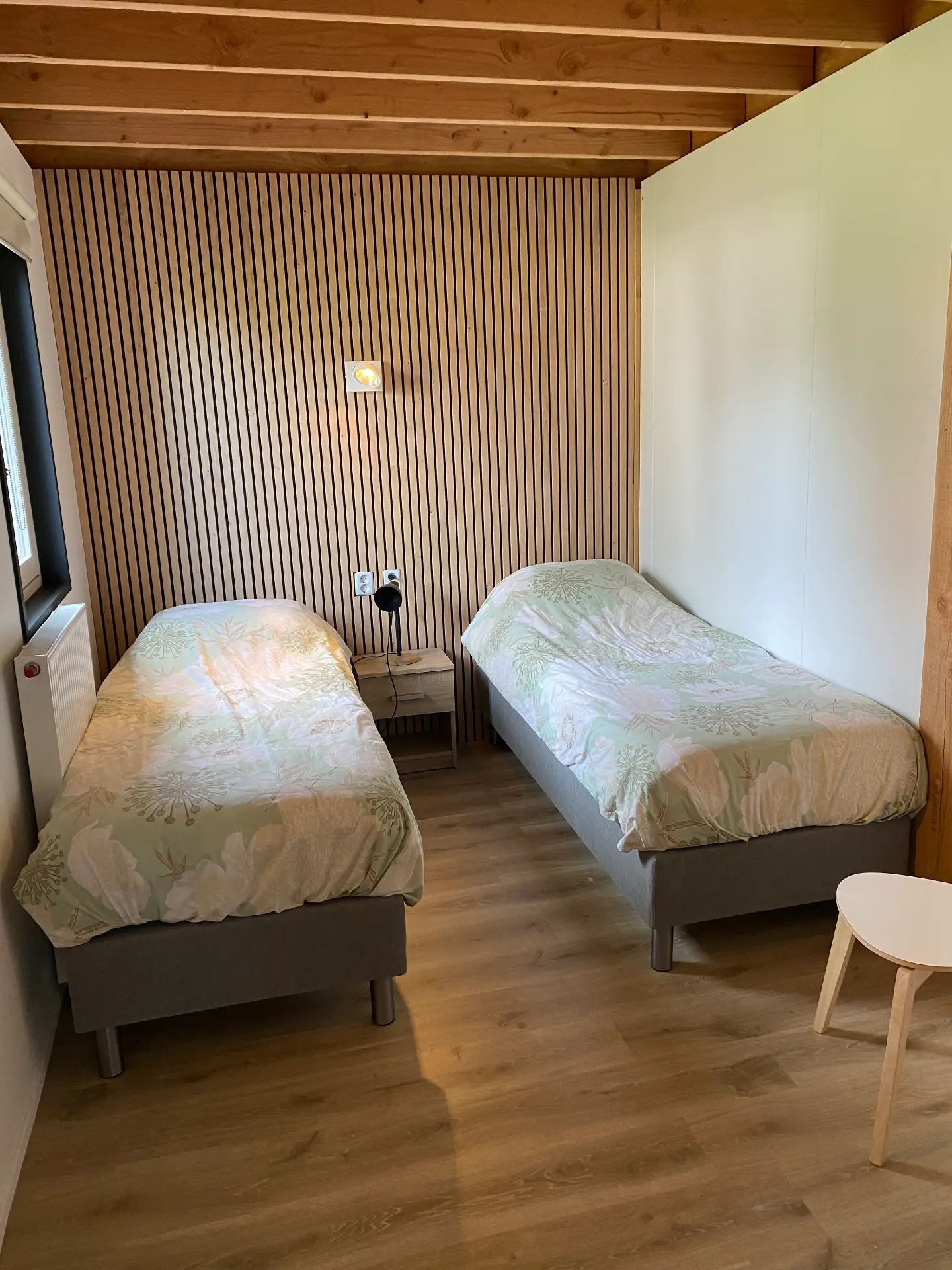 Huisje voor 11 personen: slaapkamer met twee bedden en wandlamp