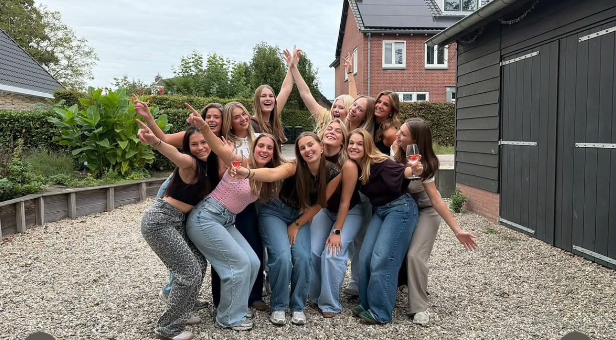 Groepsfoto op het erf naast het huisje