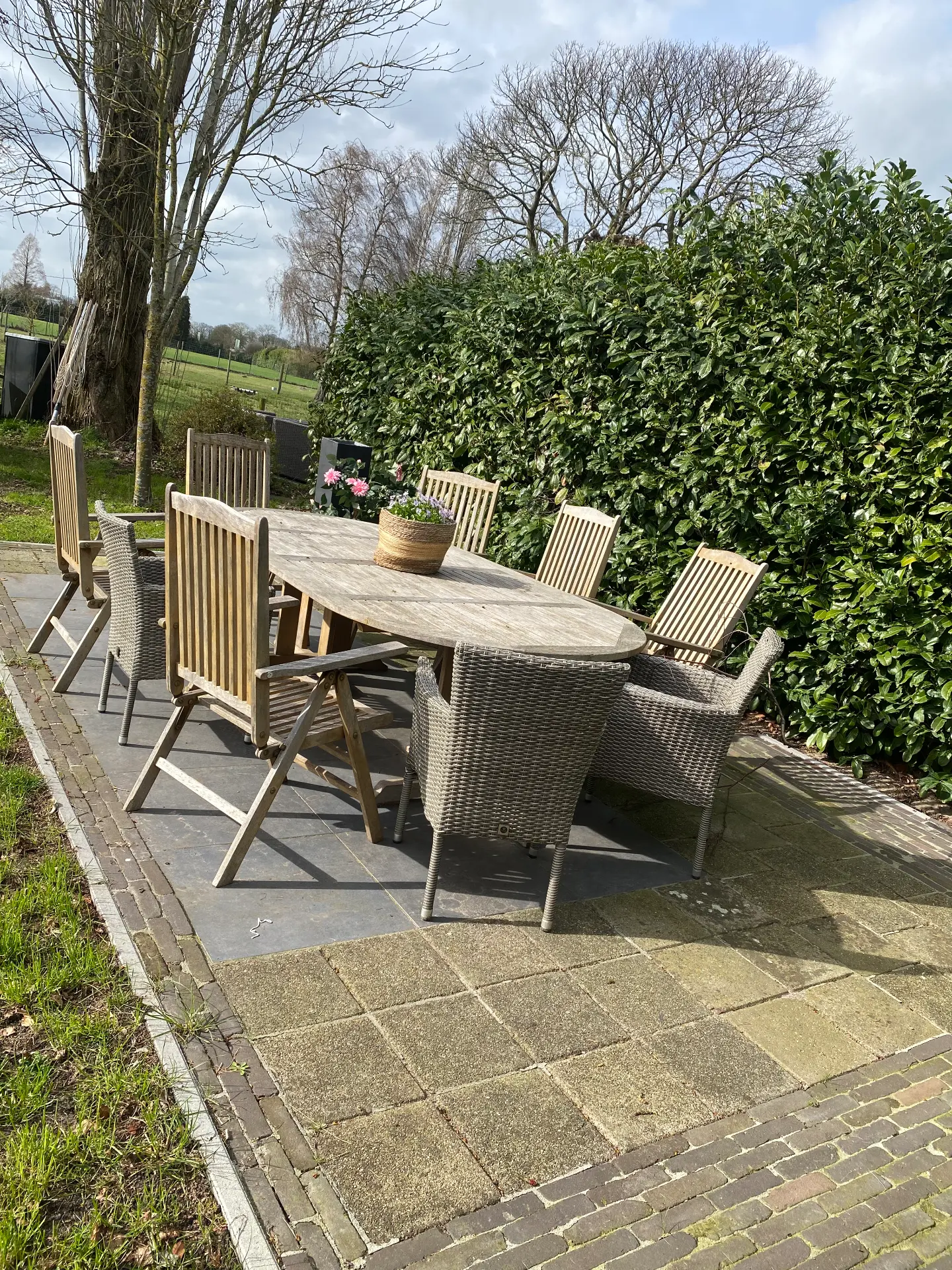 Terras met tuintafel en uitzicht op de velden bij het huisje voor 9 personen