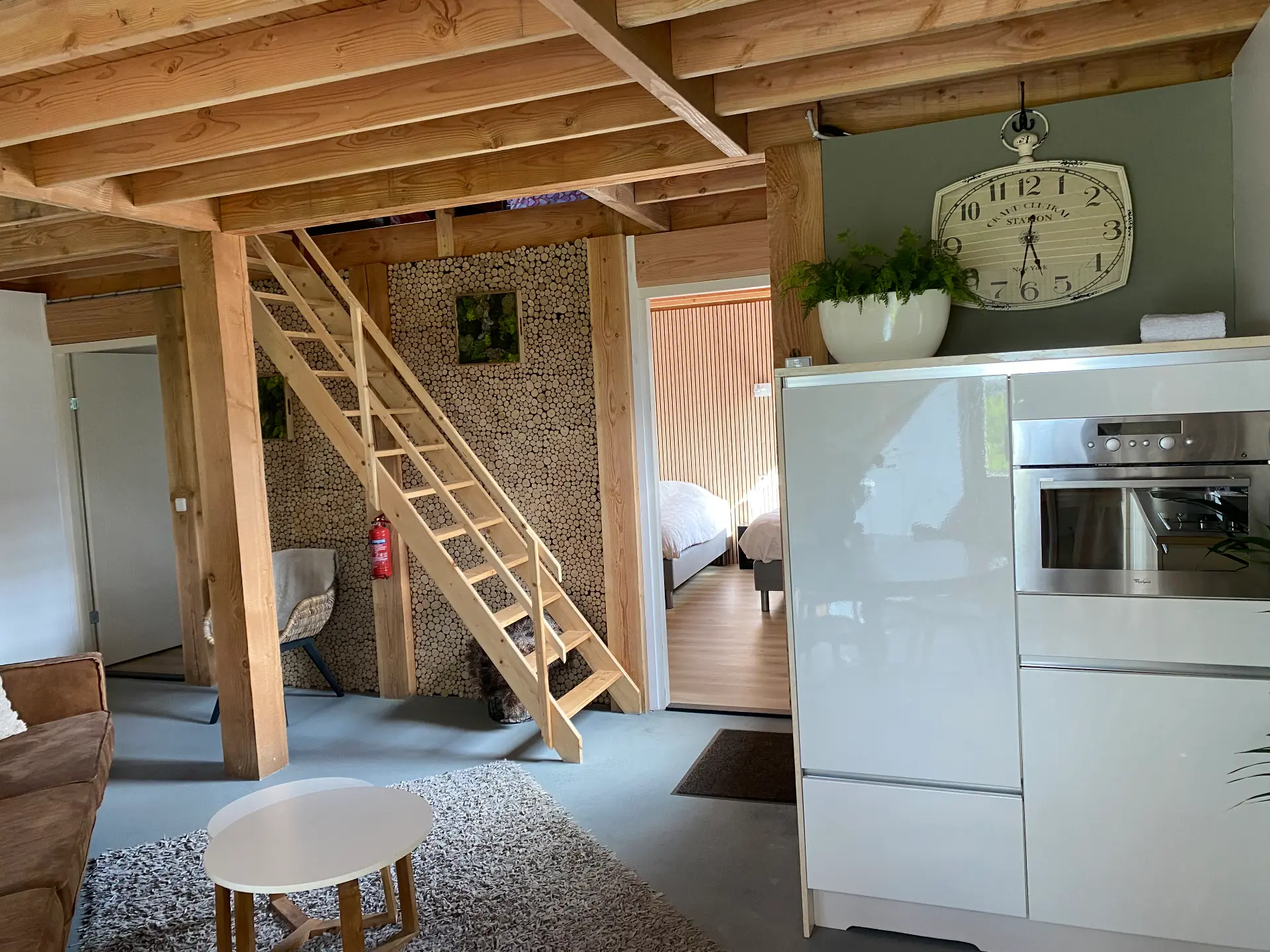 Huisje voor 11 personen: woonkamer met houten ladder naar de slaapzolder