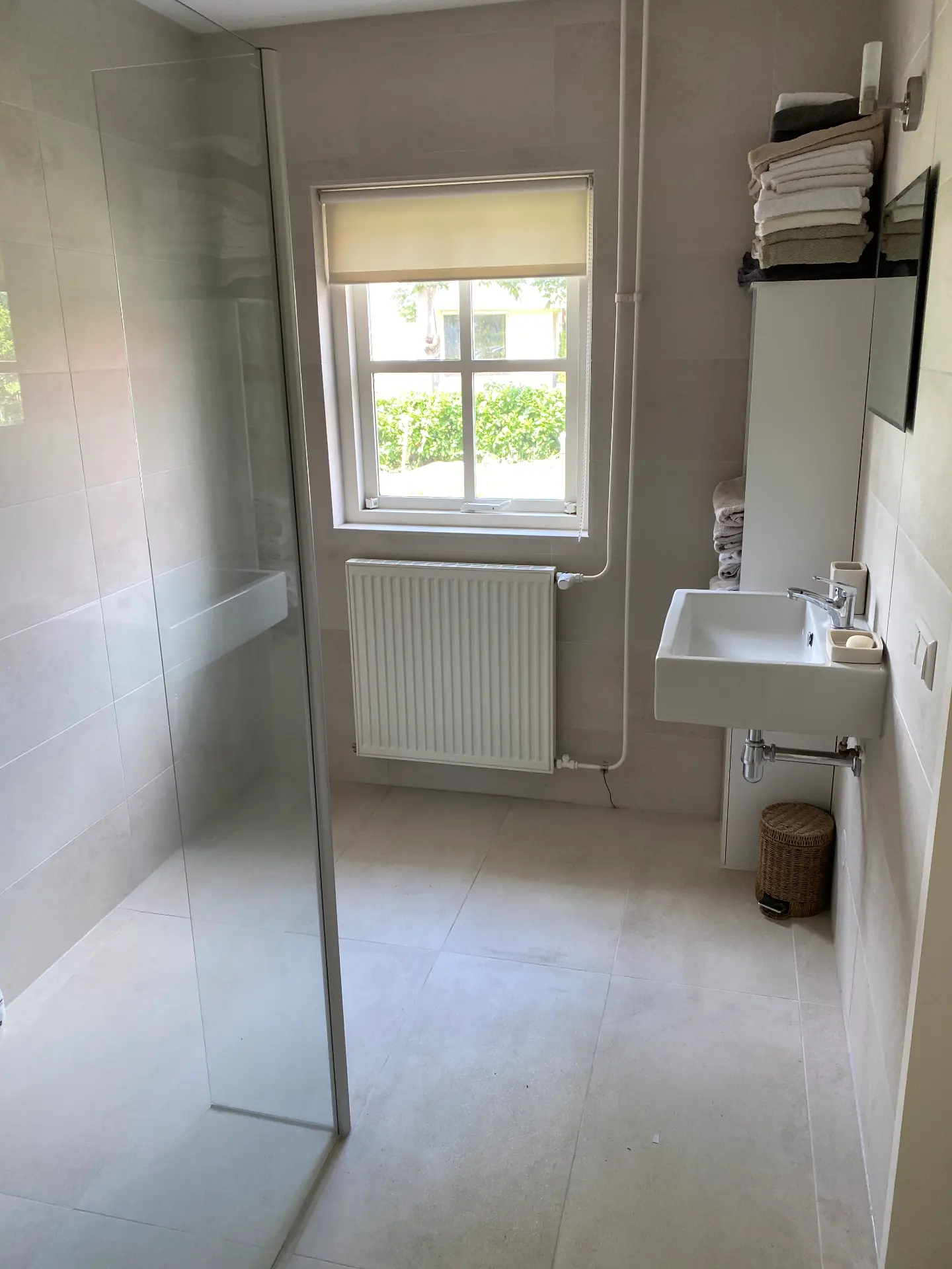 Badkamer met raam, wastafel en handdoeken