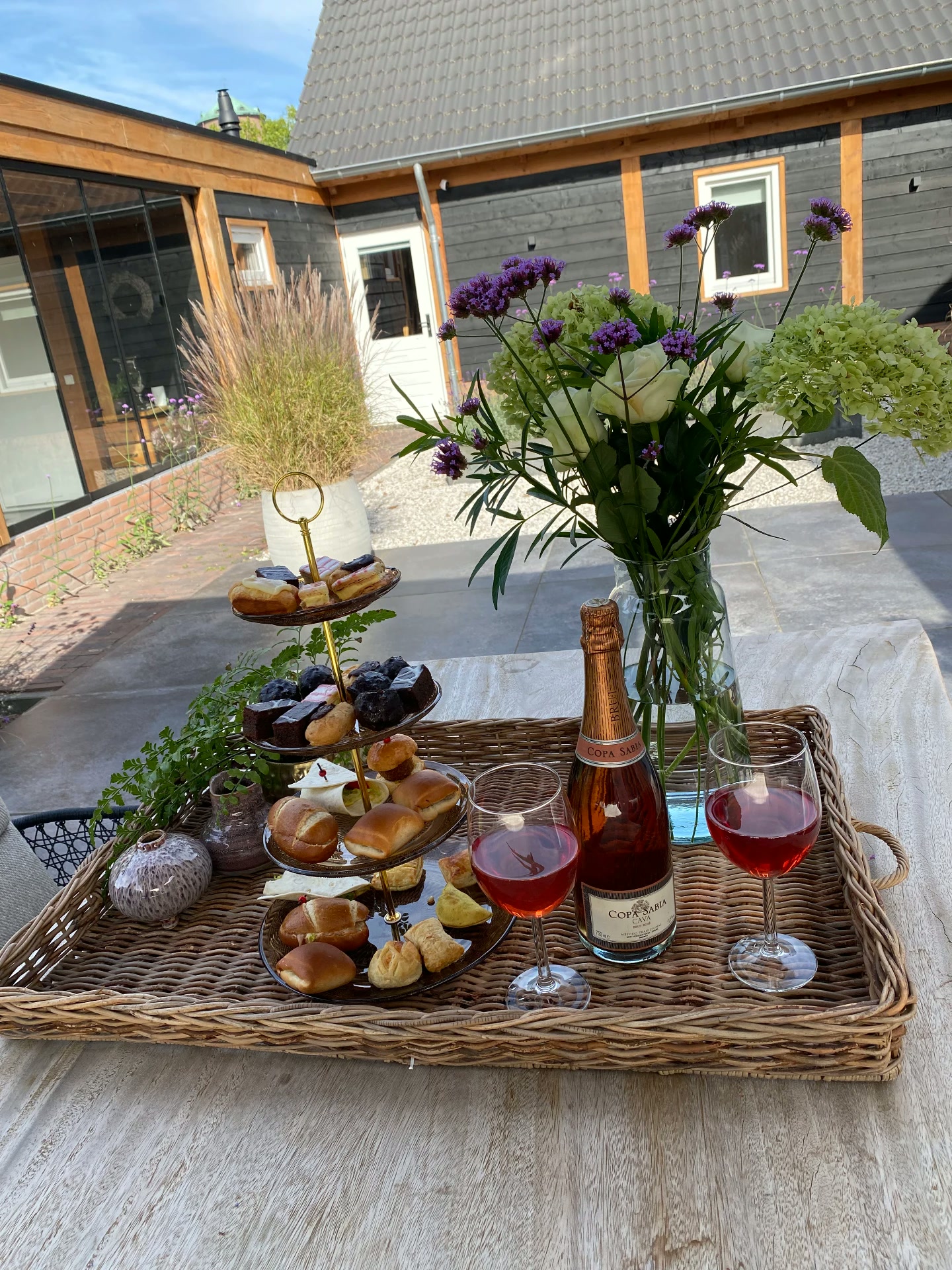 Hightea-mand met zoete lekkernijen en een glaasje cava